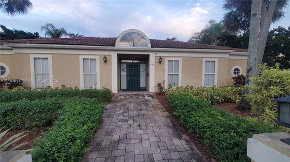 Front view of a single-story house with a central arched window and green door.