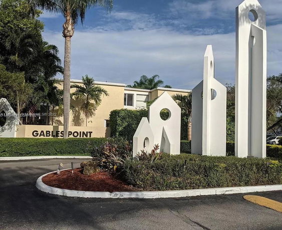 Front view of a building with 'Gables Point' signage and decorative sculptures.
