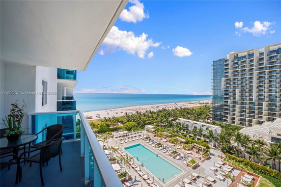 Panoramic view from a building overlooking a beach and swimming pool area.