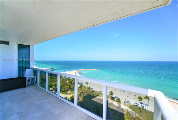 Panoramic view of the ocean seen from a balcony in a high-rise building.