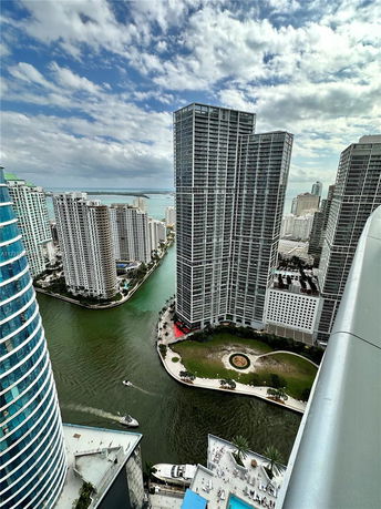 Panoramic view of a cityscape with multiple high-rise buildings and a waterway.