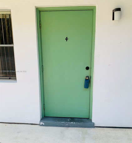 Front view of a building entrance with a green door and the number 4.