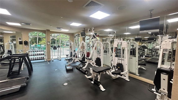 Indoor gym area with various exercise machines and equipment.