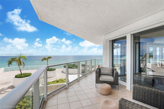 Balcony with ocean view and seating area.