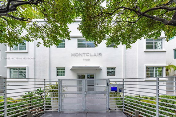 Front view of a modern two-story building with gated entrance.