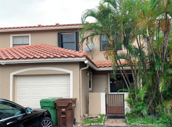 Front view of a two-story house with a tiled roof and garage.