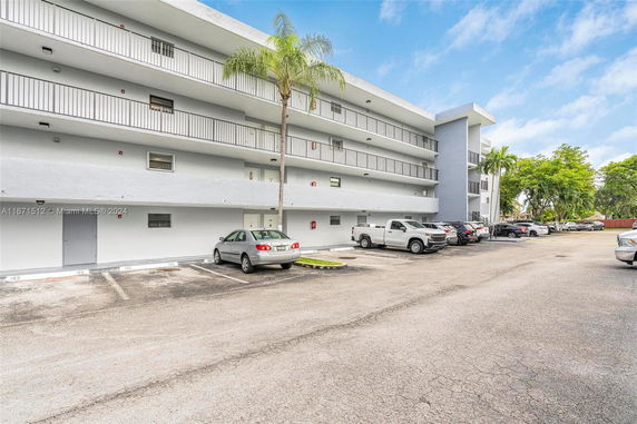 Outdoor parking area beside a multi-story residential building.