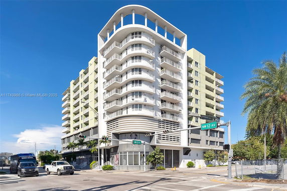 Front view of a modern multi-story apartment building with balconies.