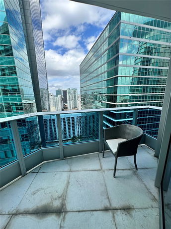 View from a balcony between tall glass buildings in a cityscape.