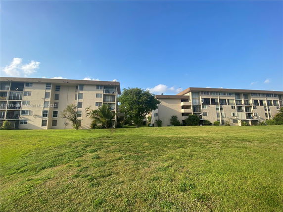 Front view of two four-story apartment buildings with balconies.