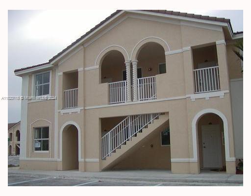 Front view of a two-story building with exterior stairs and balconies.