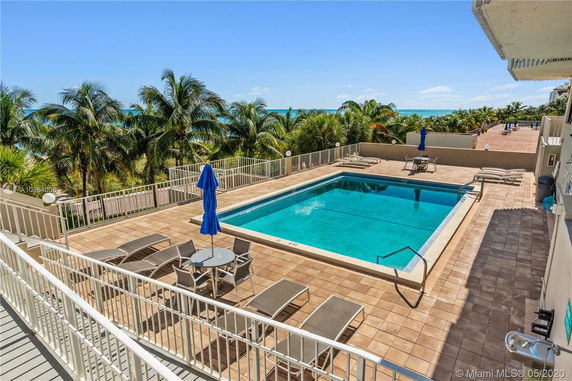 Rooftop area with a swimming pool, lounge chairs, and patio umbrellas.