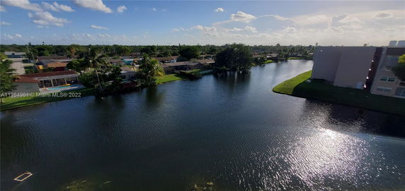 Wide angle view of a water body surrounded by residential houses and buildings.
