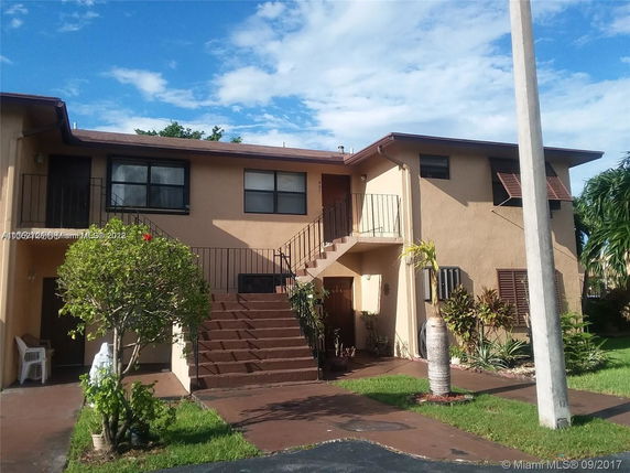 Front view of a two-story house with an external staircase.