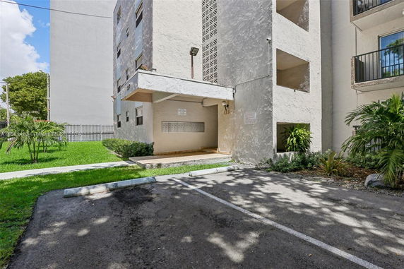 Outdoor parking area in front of a multi-story building.