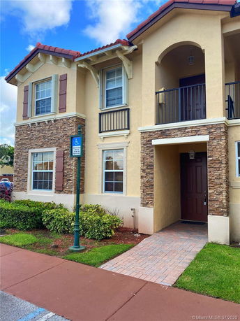 Front view of a two-story house with stone and stucco exterior.