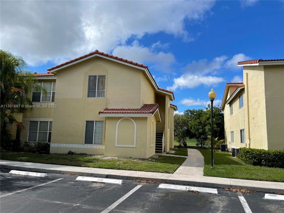 Front view of a yellow two-story building with red roof tiles.