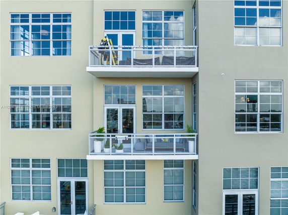 Front view of a multi-story building with large windows and balconies.