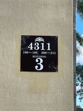 View of a building with a sign displaying numbers and building identification.