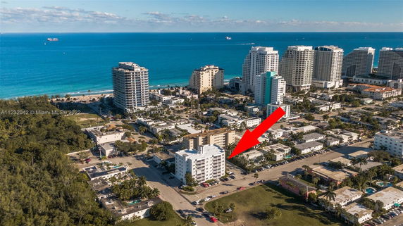 Aerial view of a coastal cityscape with multiple apartment buildings near the beach.