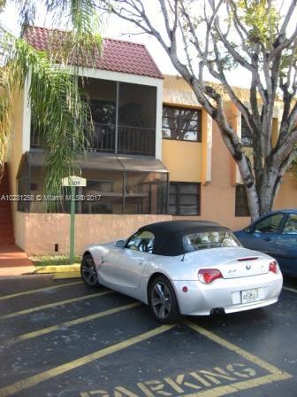 A parking area in front of a two-story residential building.