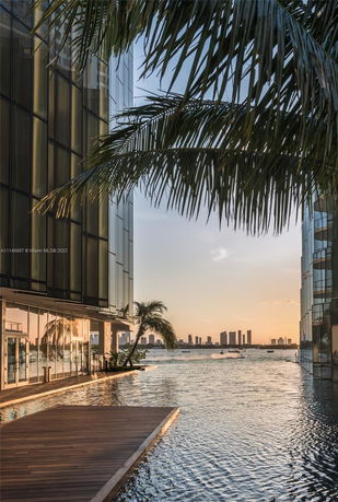 View of waterfront buildings with a city skyline in the background.