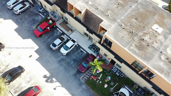 Top view of a parking area with several cars and adjacent building.