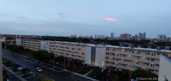 View of a multi-story residential building with surrounding cityscape in the background.