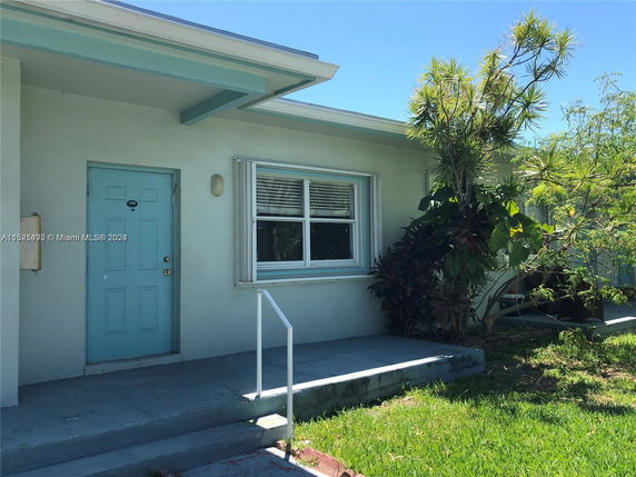 Front view of a single-story house with a light blue door and window.