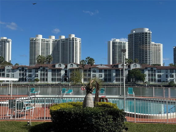 Swimming pool area with high-rise buildings in the background.
