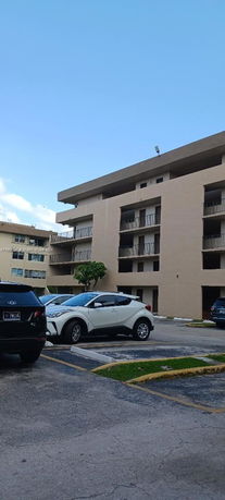 Outdoor parking area in front of a multi-story building.