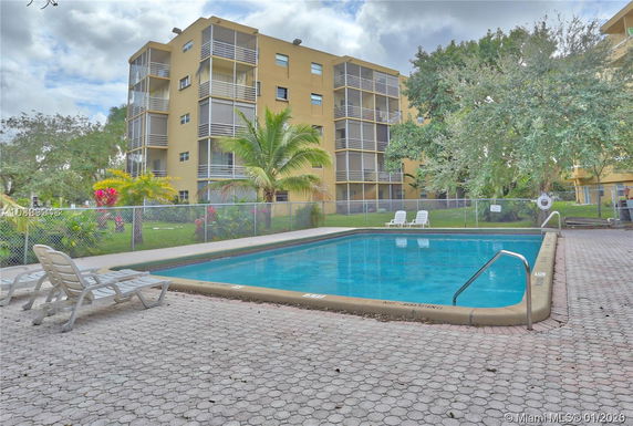 Outdoor swimming pool with adjacent multi-story residential building.