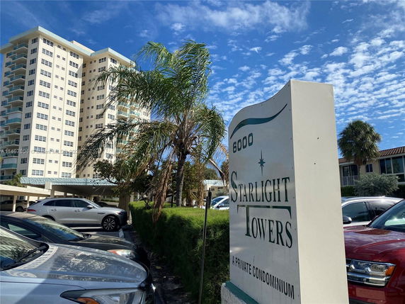 Front view of a multi-story condominium building with a sign reading 'Starlight Towers.'