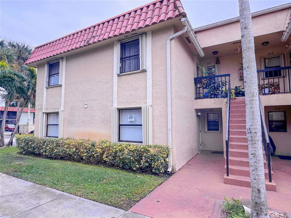 Front view of a two-story apartment building with exterior staircase.