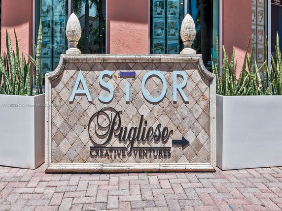 Front view of a building entrance sign with decorative stonework and lettering.