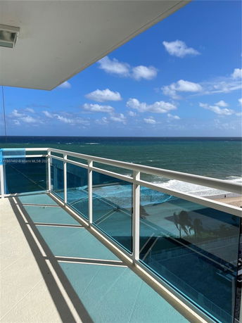 Ocean view from a balcony with glass railing.