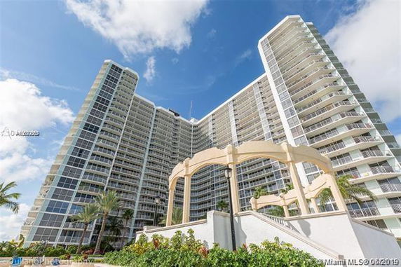 Front view of a tall residential building with multiple balconies.