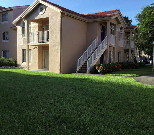 Front view of a two-story building with external staircases and balconies.