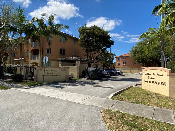 Front view of a multi-story apartment building with a gated entrance.