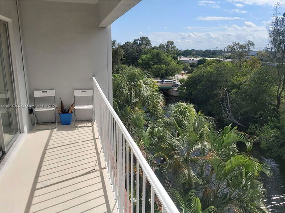 View from a balcony overlooking lush greenery and a river.