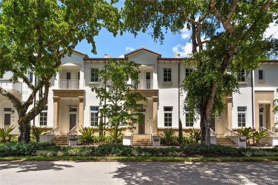 Front view of a two-story house with a symmetrical design and balconies.