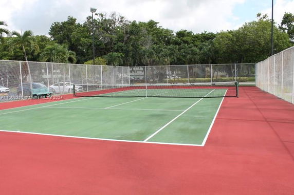 Outdoor tennis court surrounded by fencing.