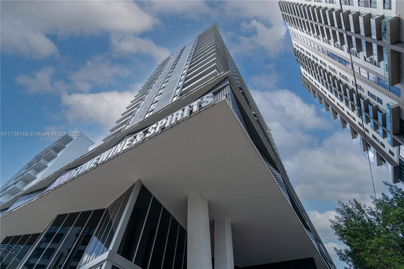 Front view of a modern multi-story building with a sign for wine and spirits.