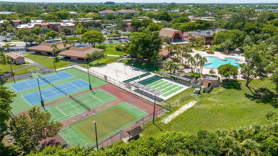 Aerial view of outdoor sports area with tennis courts and adjacent swimming pool.