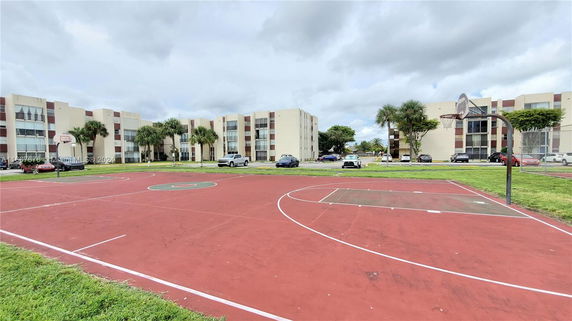 Basketball court in front of multi-story residential buildings.