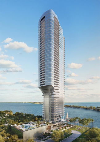 Front view of a modern high-rise building by the waterfront.