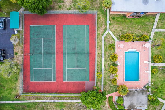 Aerial view of two adjacent tennis courts and a rectangular swimming pool in an outdoor recreational area.