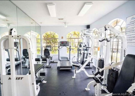 Room equipped with various gym exercise machines.