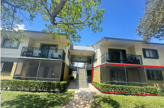 Front view of a two-story residential building with balconies and external staircases.