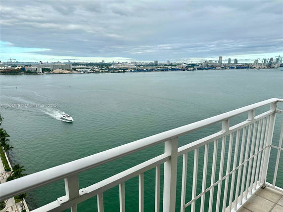 View from a balcony overlooking a large body of water with a distant cityscape.